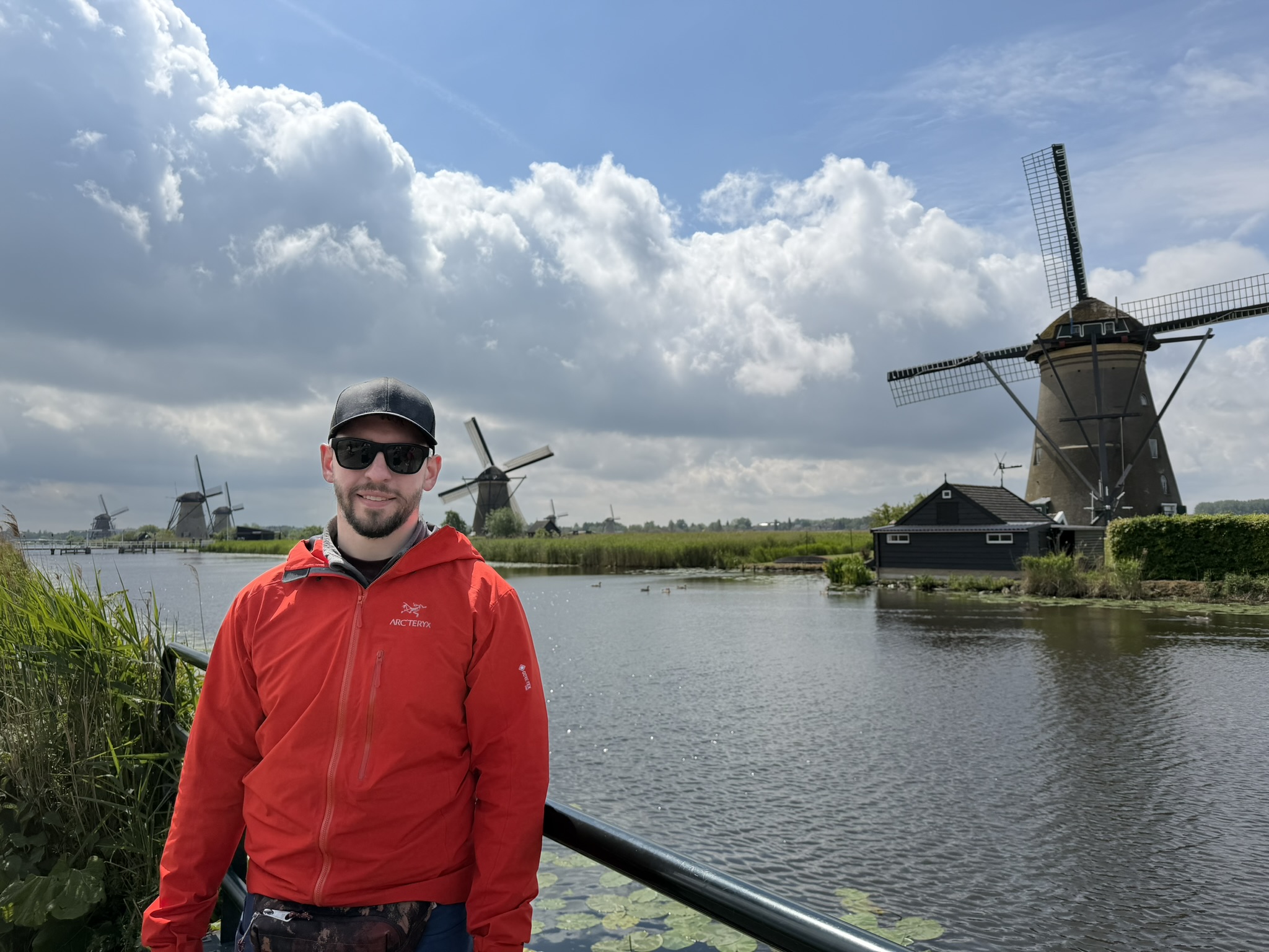 Jesse Lawrence standing beside a canal lined with historic windmills