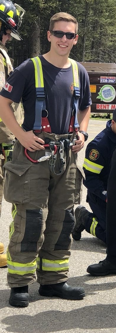 Jesse Lawrence in firefighting turnout gear and a rescue harness